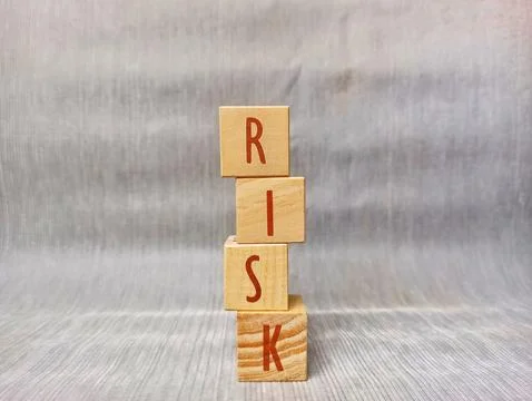 Wooden blocks spell "RISK" vertically Ilustración de archivo