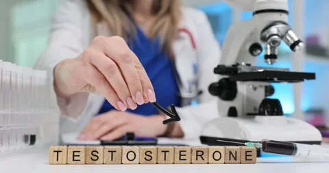 Wooden blocks spell Testosterone while doctor holds down arrow Stock Footage 314125728