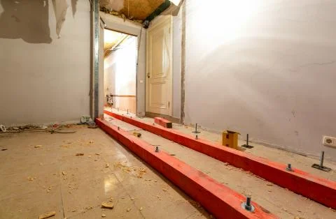 Wooden blocks on the studs for lifting up floor due installing plumbing and Stock Photos