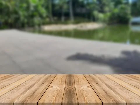 WOODEN BOARD EMPTY TABLE IN FRONT OF BLURRED FISH POND BACKGROUND Ilustración de archivo