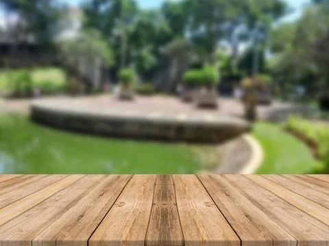 WOODEN BOARD EMPTY TABLE IN FRONT OF BLURRED FRESH FISH POND BACKGROUND Illustrazione stock