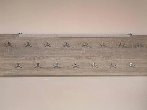 A wooden board with many hooks on it. Stock Photos