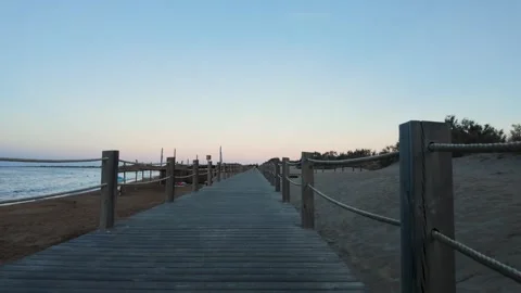 Wooden Boardwalk path on sandy beach dunes at dusk Stock Footage 344808982