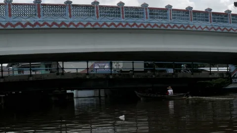 Wooden boat passing through the river, under the concrete bridge Stock Footage 132531764