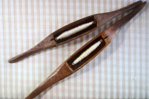 Wooden bobbin on silk fabric Stock Photos