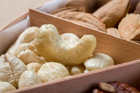 Wooden box with cells for different nuts food for health. Stock Photos