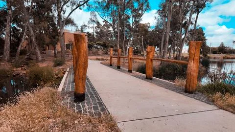 Wooden bridge with rustic timber posts over a stream creek Stock Photos