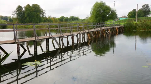 Wooden bridge through the small river in summer day Stock Footage 42812304