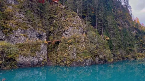 Wooden bridge trail on cliff over crevasse above turquoise water Stock Footage 290220372