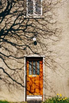 Wooden brown door with rectangular windows in the building under the windo... Stock Photos
