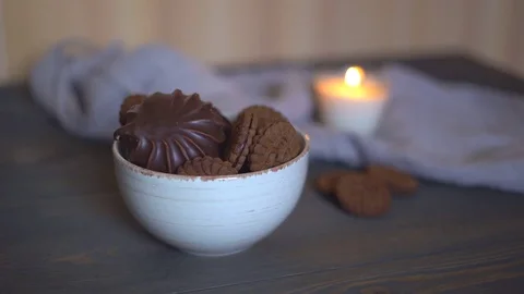 Wooden brown table. on the table is a lot of chocolate biscuits with stuffing. a Stock Footage 82011199