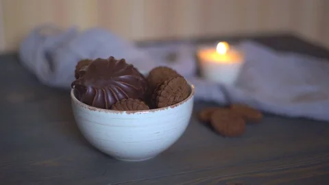 Wooden brown table. on the table is a lot of chocolate biscuits with stuffing. a Stock Footage 82011638
