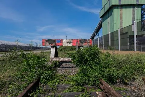Wooden buffer stop with red stop sign ending rail tracks concept for limit Stock Photos