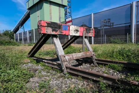 Wooden buffer stop with red stop sign ending rail tracks concept for limit Foto stock