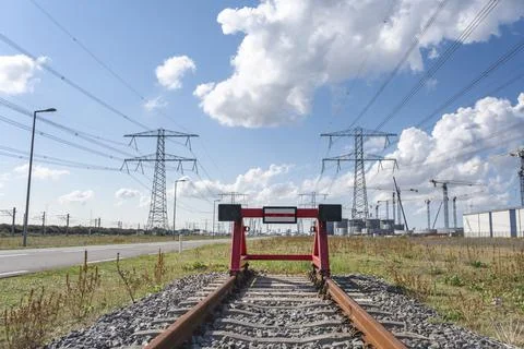 Wooden buffer stop with red stop sign ending rail tracks concept for limit Stock Photos
