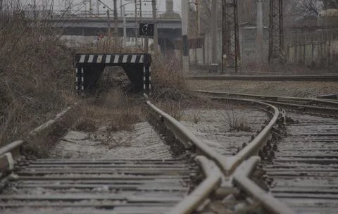 Wooden buffer stop with red stop sign ending rail tracks concept for limit, l Stock Photos