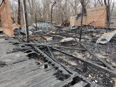 Wooden buildings burned to the ground in Ukraine in February 2022 after an attac Stock Photos