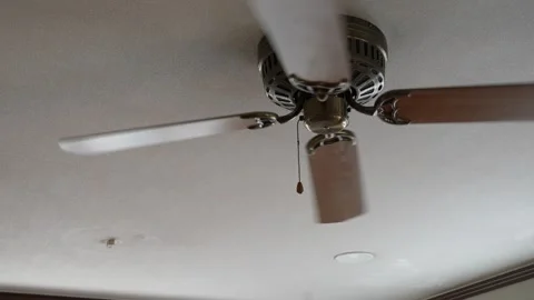 Wooden ceiling fan spinning continuously on plain ceiling Stock Footage 346342020