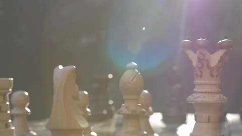 Wooden chess game on a table in a camera slide from left to right against sun Stock Footage 118721160