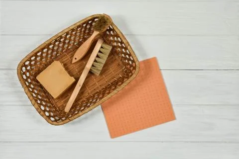 Wooden cleaning brushes and solid natural soap in a basket on a white background Stock Photos