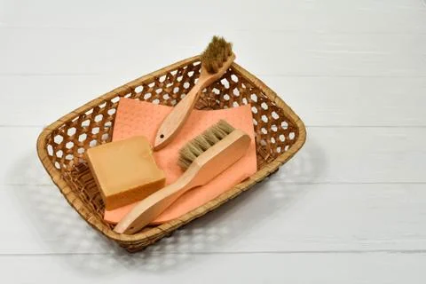 Wooden cleaning brushes and solid natural soap in a basket on a white background 스톡 사진