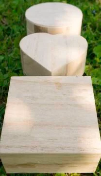 Wooden closed boxes in the shape of a cube, heart and circle on a green grass Stock Photos