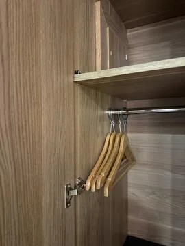 Wooden closet interior with empty hangers on metal rod, ideal background fo.. Stock Photos