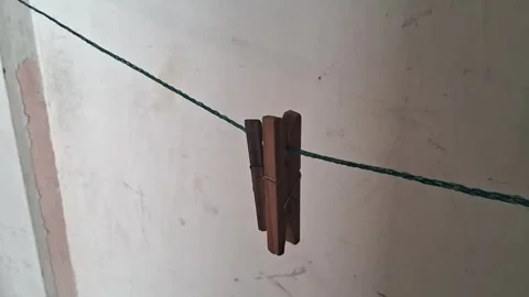 Wooden clothespin hanging on a simple string in motion video 库存影片 337844183