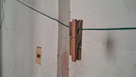 Wooden clothespin hanging on a thin string motion video footage 動画素材 337844186