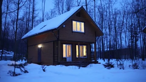 Wooden cottage with light in the windows on an Video stock 299636622