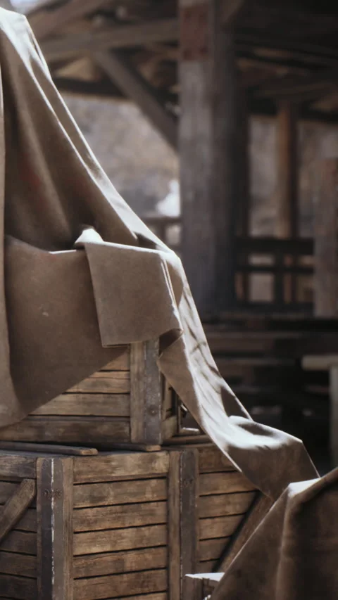 Wooden crates covered with cloth in a rustic outdoor setting during daytime Stock Footage 337901732