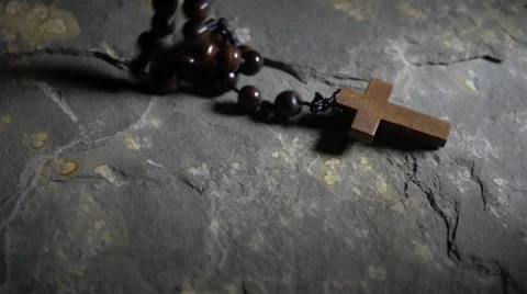 Wooden cross and rosary falling onto stone floor, slow motion Stock Footage