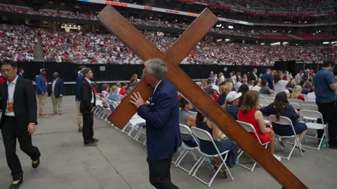 A wooden cross is carried between rows of seats at the Charlie Kirk memorial Stock Footage 345297915