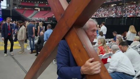 A wooden cross is carried through the crowd at the Charlie Kirk memorial service Stock Footage 345297853