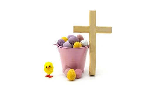 Wooden Cross with Easter Candy Eggs in Pink Bucket and a Yellow Chick Stock Photos