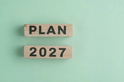 Wooden cube with 2027 PLAN text isolated on a paper background, representin.. Stock Photos