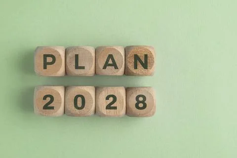 Wooden cube with 2028 PLAN text isolated on a paper background, representin.. Stock Photos