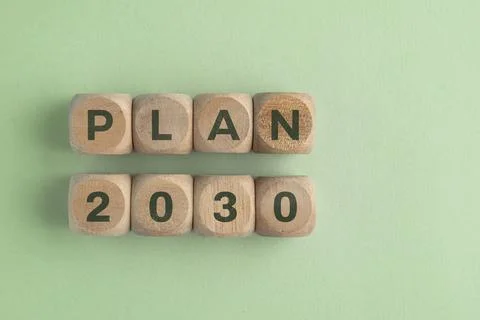 Wooden cube with 2030 PLAN text isolated on a paper background, representin.. Stock Photos