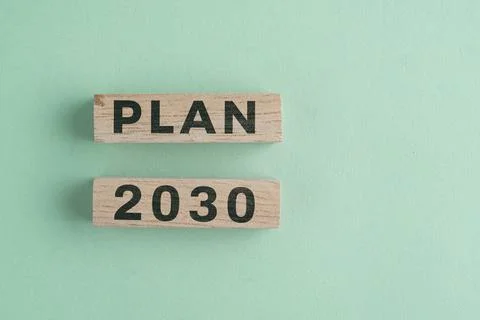 Wooden cube with 2030 PLAN text isolated on a paper background, representin.. Stock Photos