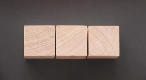 Wooden cube block shape withcopyspace on dark grey table Stockfoto's