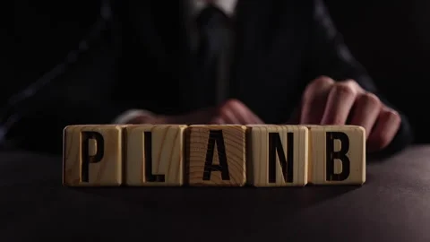 Wooden cube blocks with PLAN A change to PLAN B text on table. Stock Footage 246690409