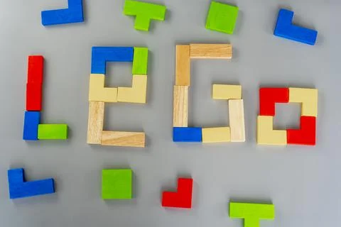 Wooden cube on the gray background. Multi-colored cubes on the table. Geometric Stock Photos