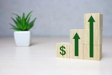 Wooden cube stack as a graph with arrows pointing up on white background. Con Stock Photos