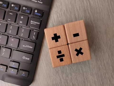 Wooden cubes displaying basic mathematical operator symbols arranged on a s.. Stock Photos