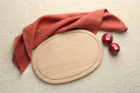 Wooden cutting board, cloth and spice shakers on beige table, flat lay. Spa.. Stock Photos