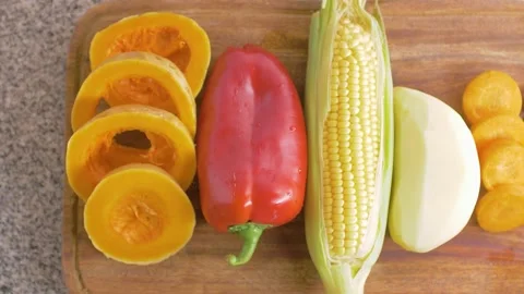 Wooden cutting table full of vegetables 2 SHOTS Onion Potatoe Bell Pepper Carrot Stock Footage 130835872