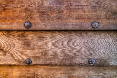 Wooden dark brown pattern, horizontal old boards and fixed iron rivets Stock Photos