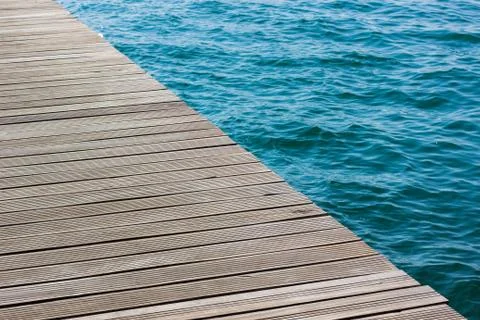 Wooden deck diagonal surface unfocused water background sea waterfront simple Stock Photos