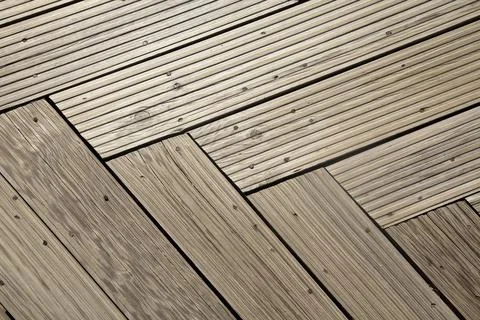 Wooden deck with distinctive herringbone pattern under soft lighting Stock Photos