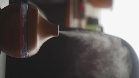 A wooden diffuser for essential oils moisturizes the air with diffusing steam Stock Footage 124580285
